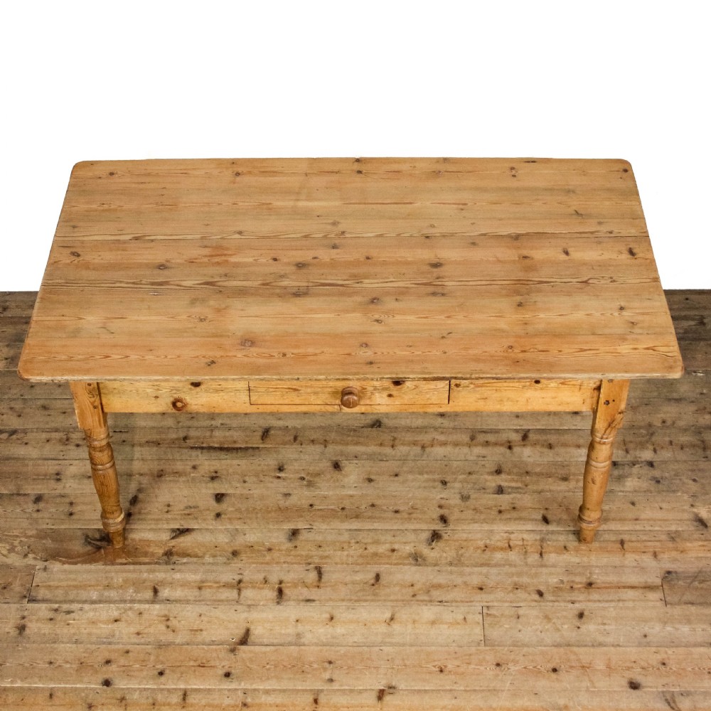 A large antique pine farmhouse kitchen table featuring a plank top, turned legs, and a single frieze drawer with a wooden knob. View XIII