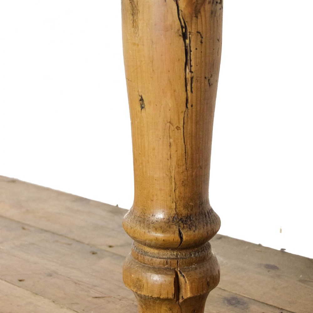 A large antique pine farmhouse kitchen table featuring a plank top, turned legs, and a single frieze drawer with a wooden knob. View XVI