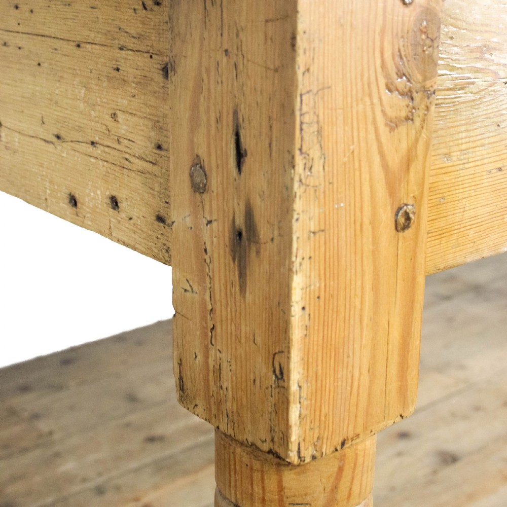 A large antique pine farmhouse kitchen table featuring a plank top, turned legs, and a single frieze drawer with a wooden knob. View XVII