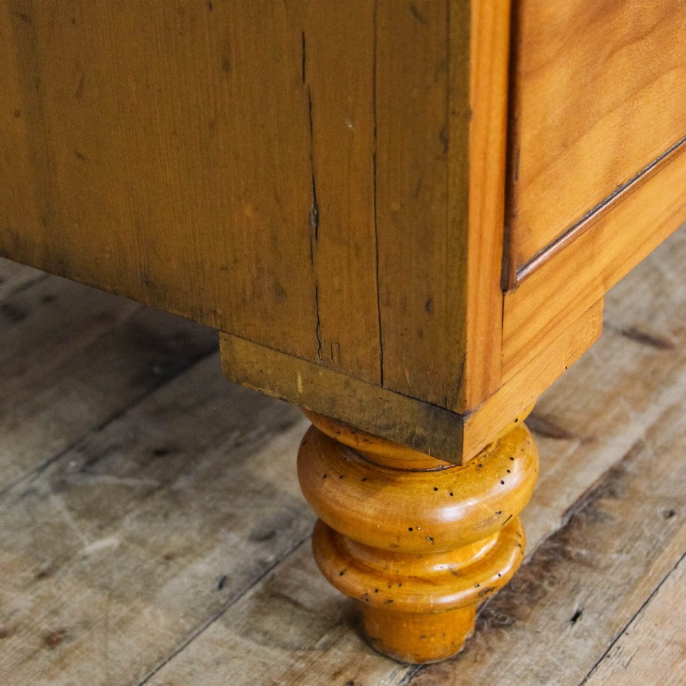 A late Victorian satin walnut chest of drawers featuring two short over three long drawers with turned wooden knob handles and turned feet. View XI