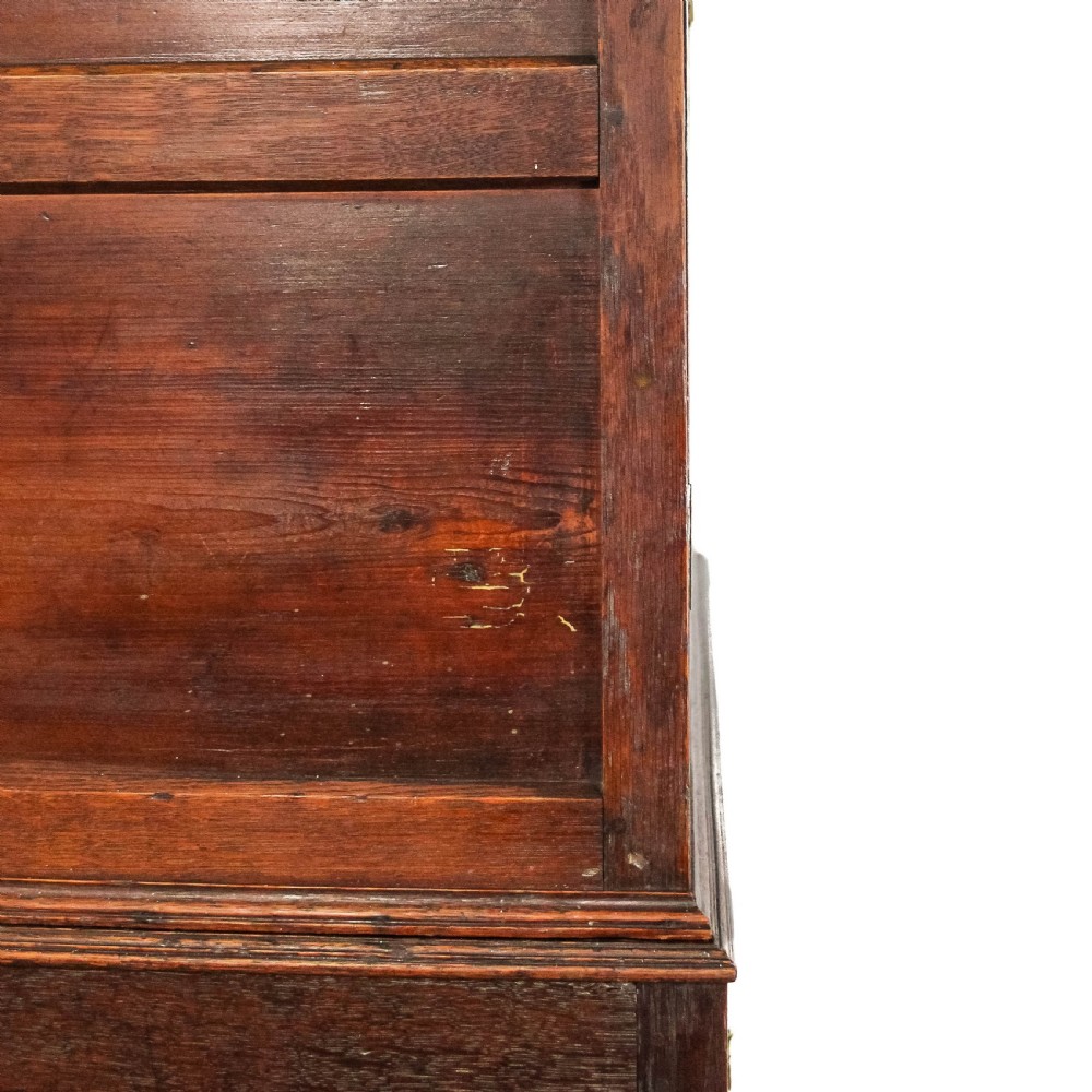 An antique dark oak linen press cabinet featuring two panelled upper doors above a lower chest containing seven drawers with brass swan-neck handles. View VI