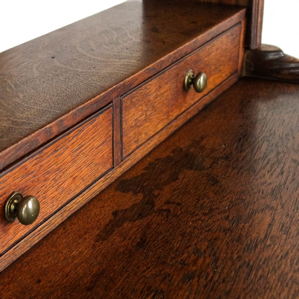 An 18th-century Welsh oak dresser featuring a three-shelf open plate rack with cup hooks, five small spice drawers, three main drawers with brass handles, a shaped apron, turned front supports, and a lower potboard shelf. View VIII