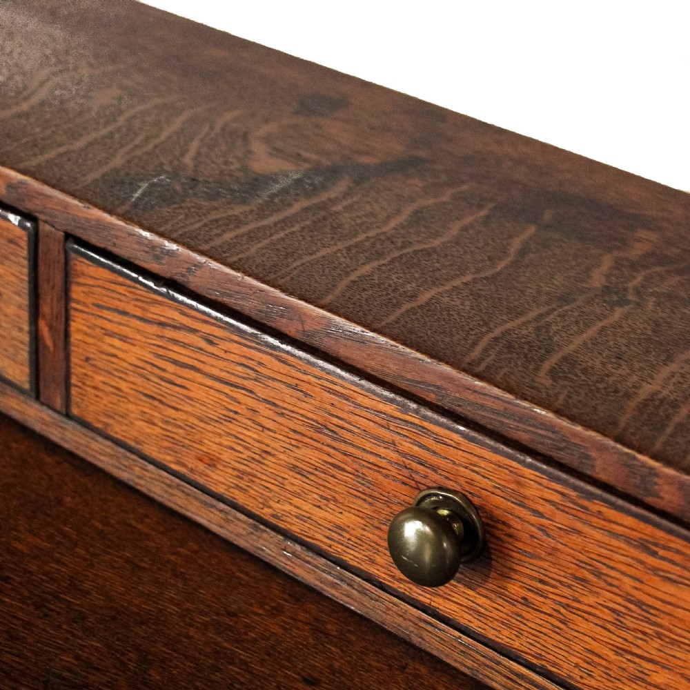 An 18th-century Welsh oak dresser featuring a three-shelf open plate rack with cup hooks, five small spice drawers, three main drawers with brass handles, a shaped apron, turned front supports, and a lower potboard shelf. View XI