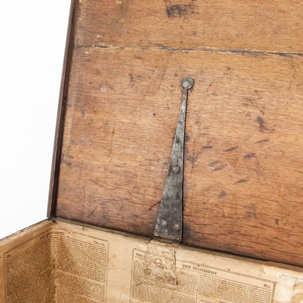 A nineteenth-century dark brown oak coffer on stand featuring a hinged top lid, a single lower drawer with brass handles, and bracket feet. View X