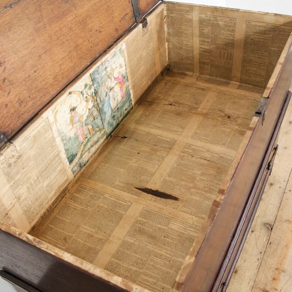 A nineteenth-century dark brown oak coffer on stand featuring a hinged top lid, a single lower drawer with brass handles, and bracket feet. View XII