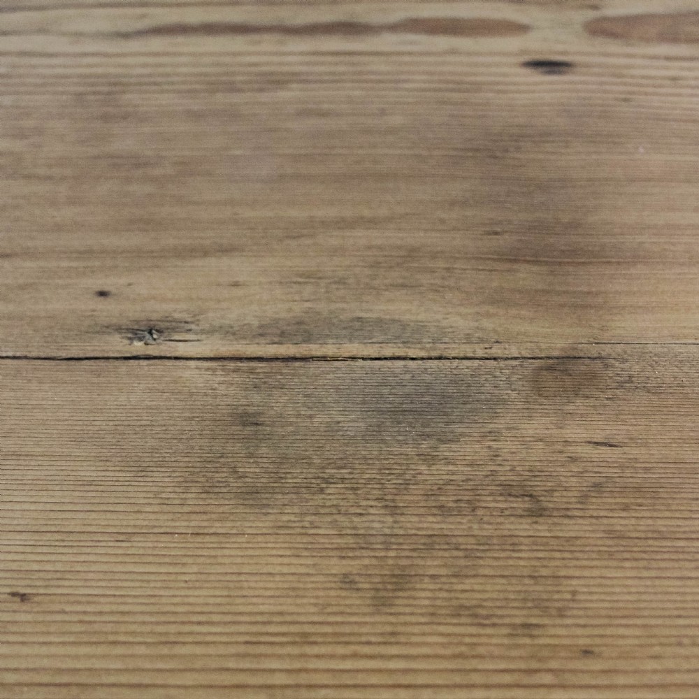 An antique circular pine cricket table with three turned wooden legs and a deep triangular apron beneath the tabletop. View II