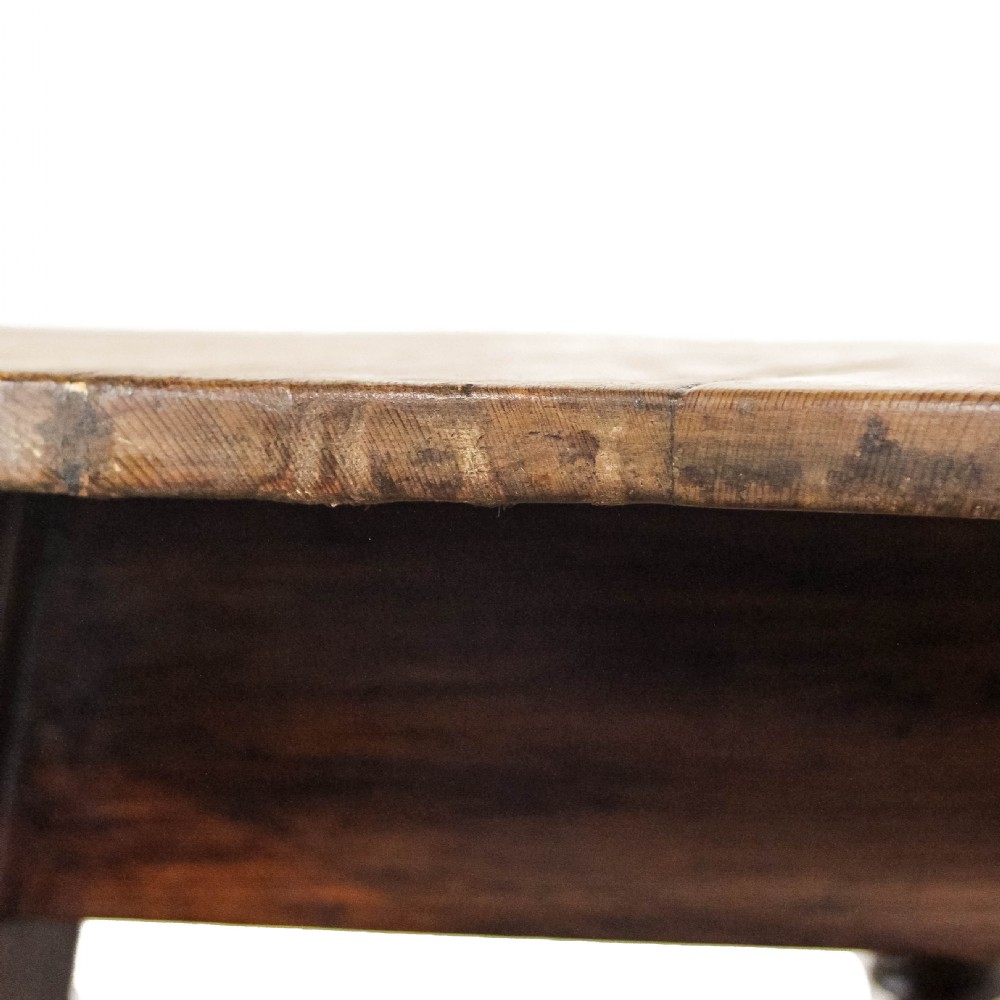 An antique circular pine cricket table with three turned wooden legs and a deep triangular apron beneath the tabletop. View V