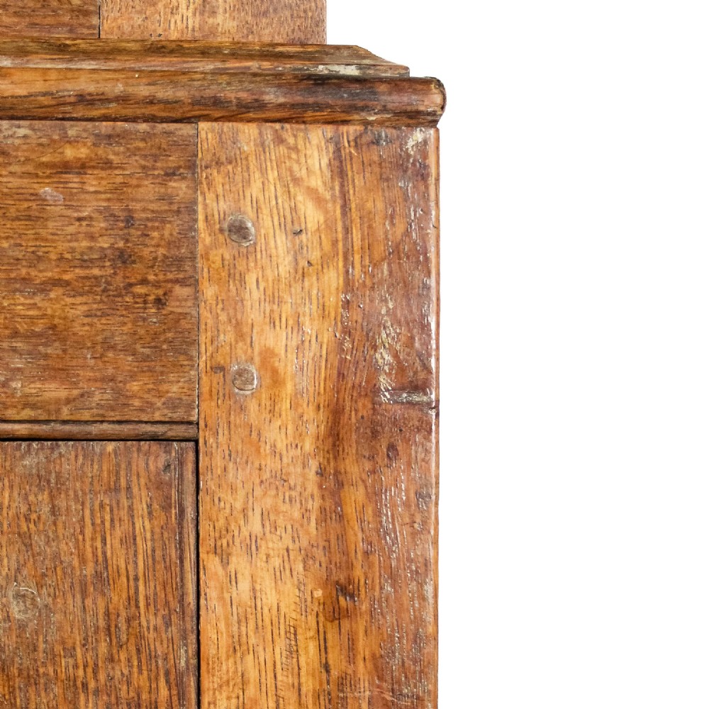 A 19th-century oak linen press featuring two top panelled doors, three central drawers, and a lower double-door cupboard on bracket feet. View IX
