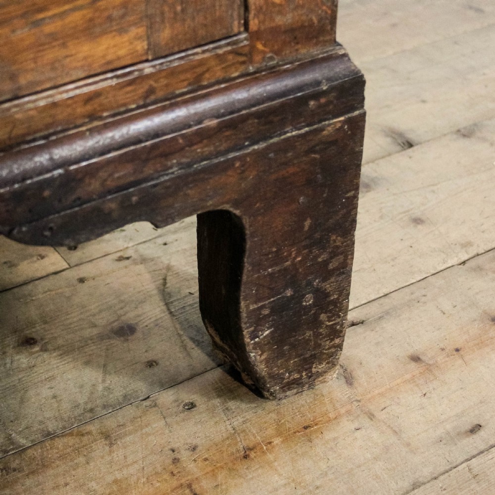A 19th-century oak linen press featuring two top panelled doors, three central drawers, and a lower double-door cupboard on bracket feet. View X