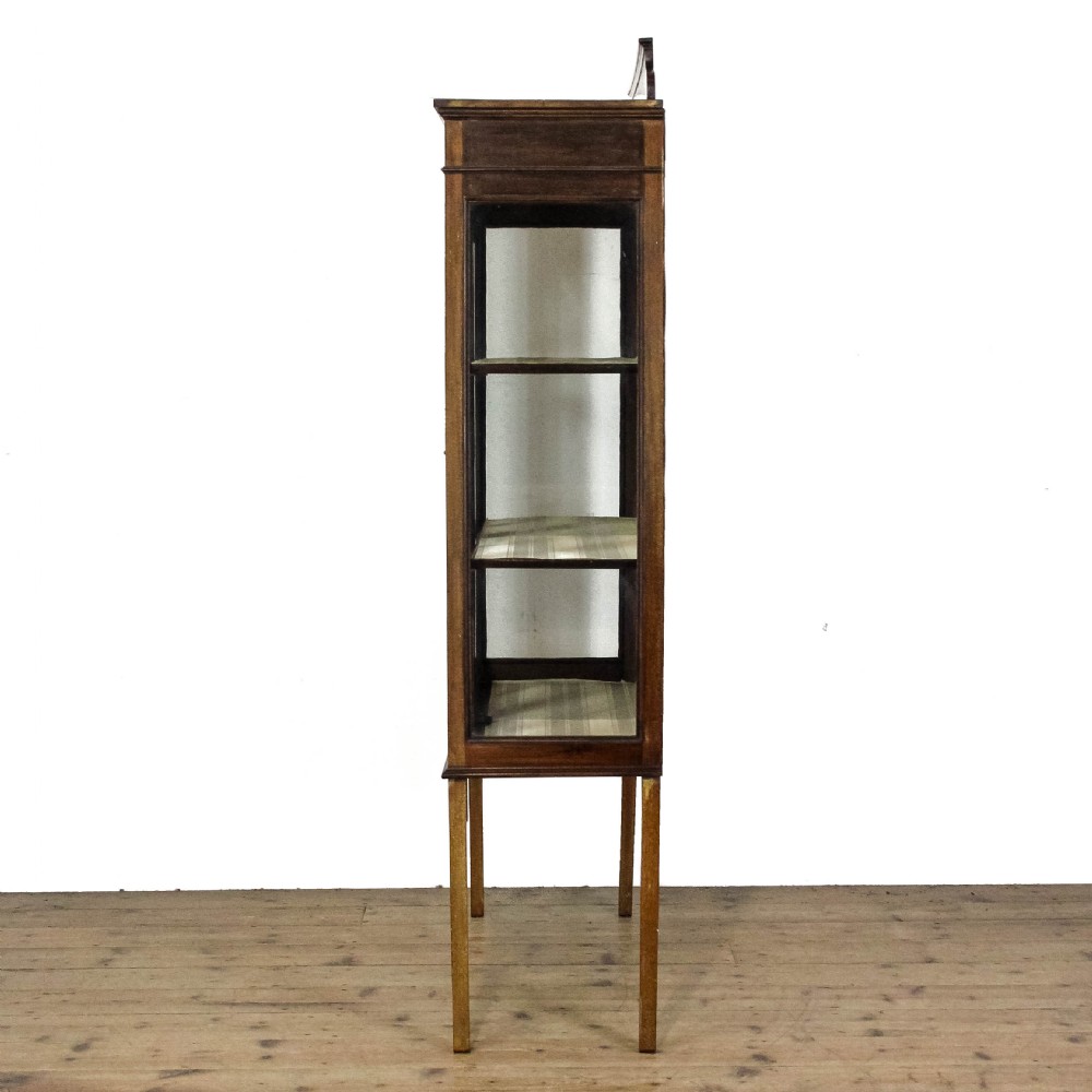 An antique Edwardian mahogany display cabinet featuring inlaid garland swags on the top frieze, twin glazed doors with gothic astragal bars, and slender square legs. View VI