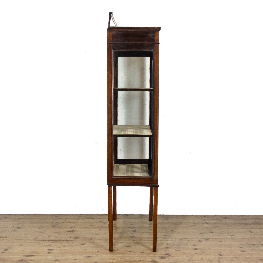 An antique Edwardian mahogany display cabinet featuring inlaid garland swags on the top frieze, twin glazed doors with gothic astragal bars, and slender square legs. View IX