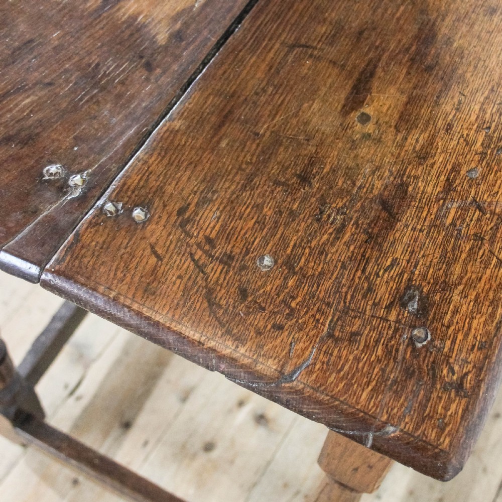 An 18th-century oak side table featuring a rectangular top, a single frieze drawer, four baluster-turned legs, and low box stretchers. View X