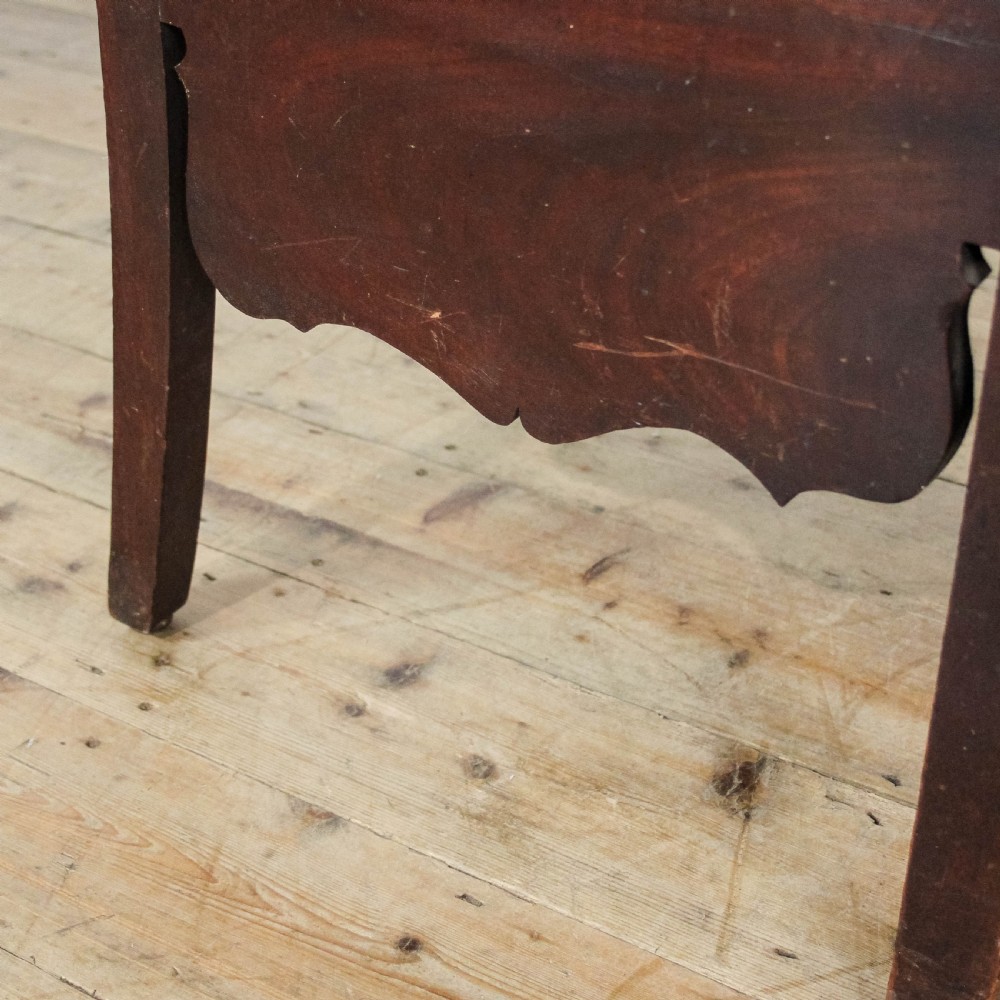 An antique dark mahogany commode chair featuring turned arm supports, a bar back frame, and an olive green drop-in seat pad. View VII