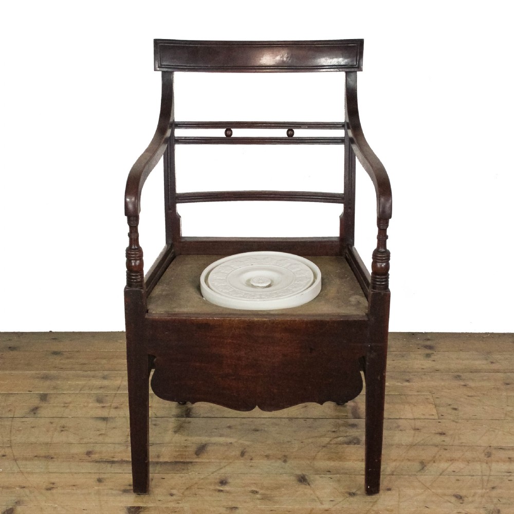 An antique dark mahogany commode chair featuring turned arm supports, a bar back frame, and an olive green drop-in seat pad. View IX