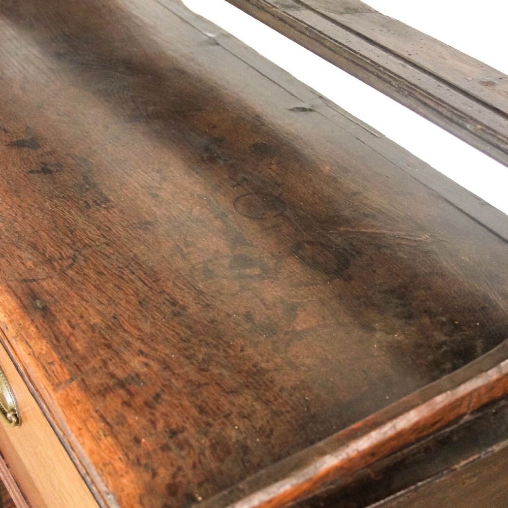 An antique dark oak open-potboard dresser featuring an upper three-tier plate rack with hooks, three drawer units with brass oval handles, and four square legs supporting a slatted lower shelf. View IV