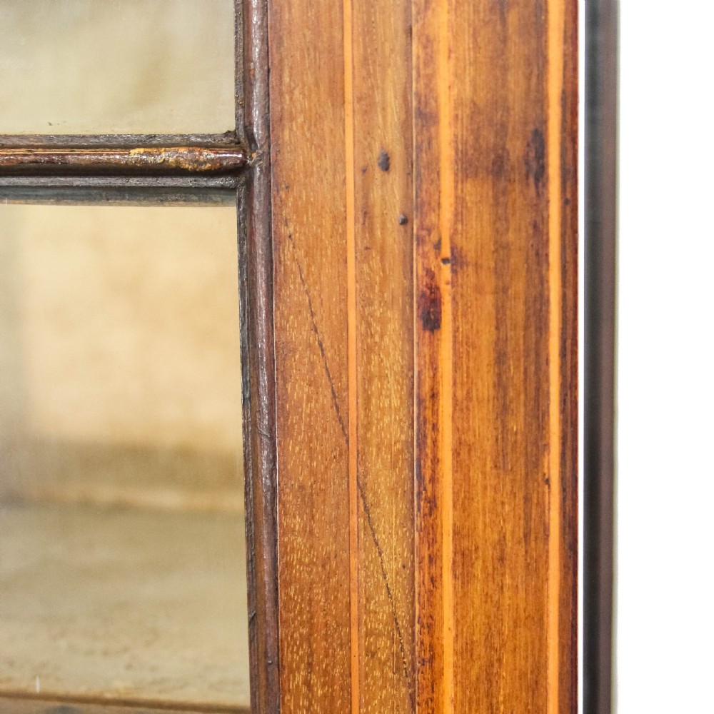 An Edwardian mahogany display cabinet featuring a painted floral frieze, a single glazed door with diamond astragal bars, and tall square tapered legs. View XI