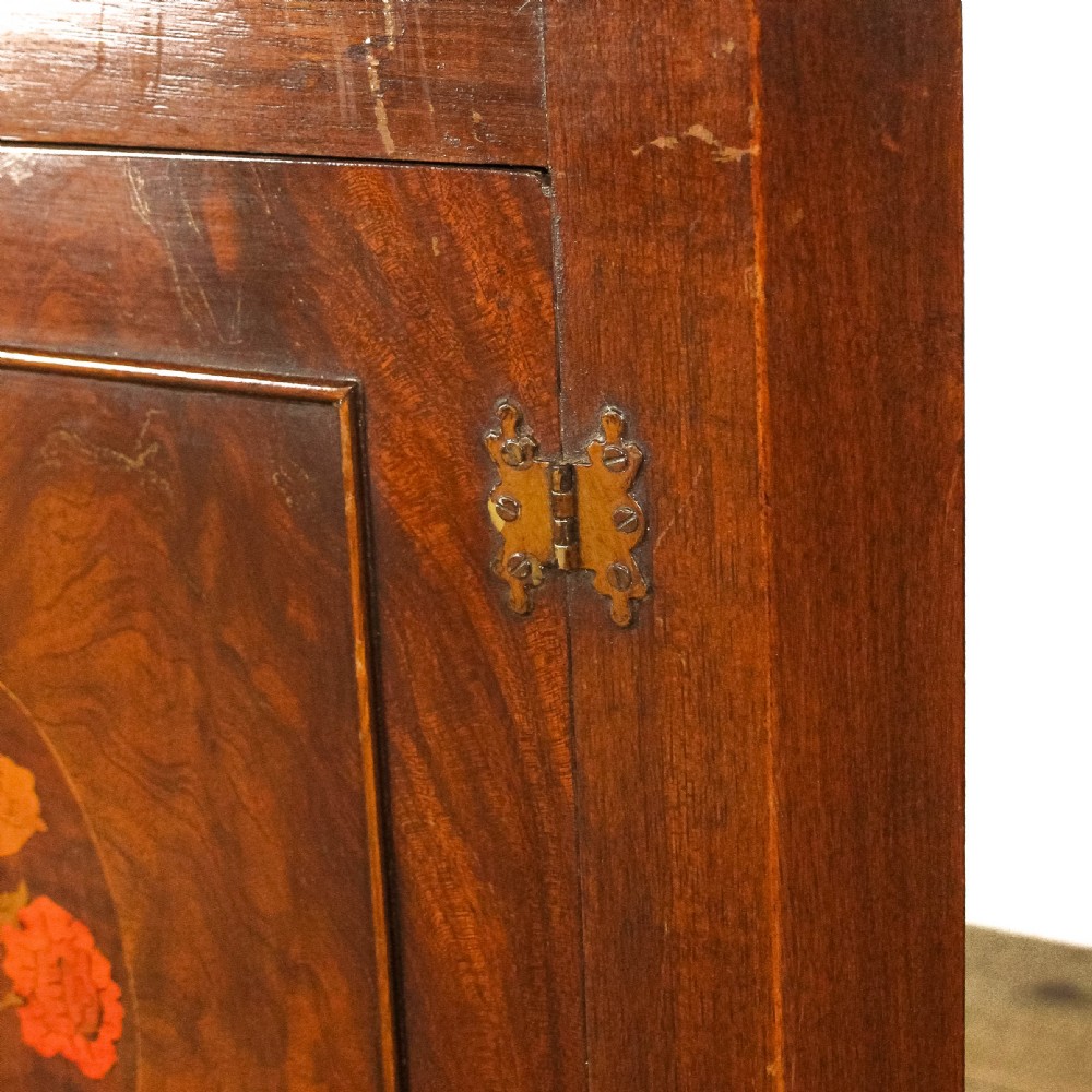 A pair of tall mahogany corner cabinets with arched tops, blue-painted shelf interiors, and floral inlaid panels on the lower door. View VI