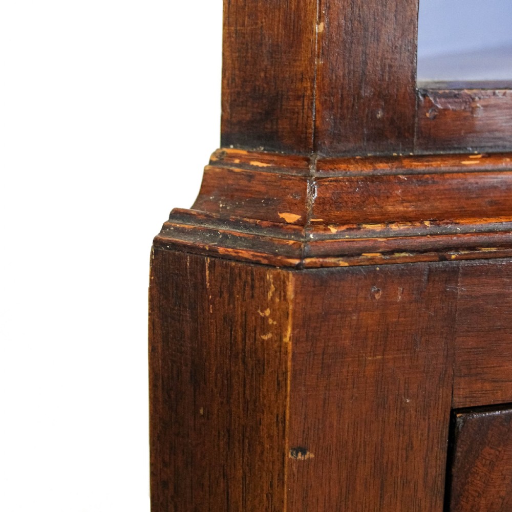 A pair of tall mahogany corner cabinets with arched tops, blue-painted shelf interiors, and floral inlaid panels on the lower door. View IX