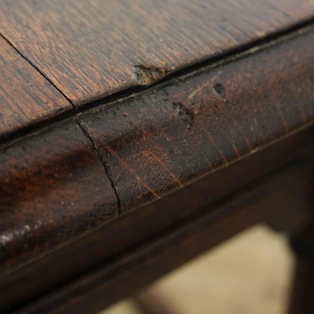 A square dark oak joint stool featuring turned legs, peg joinery, and a low perimeter box stretcher. View IX