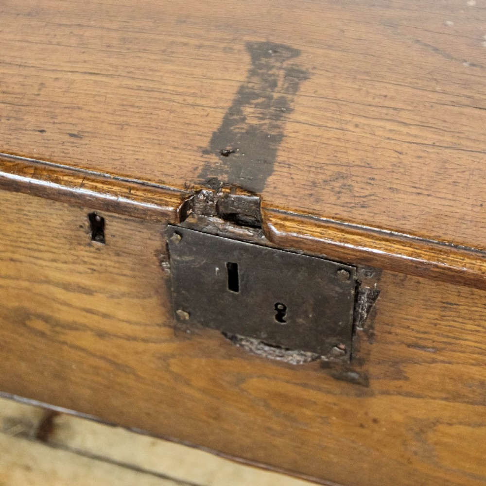 An 18th-century solid oak sword chest featuring a rectangular lift-top lid, iron lockplate, and cutout side supports. View VIII