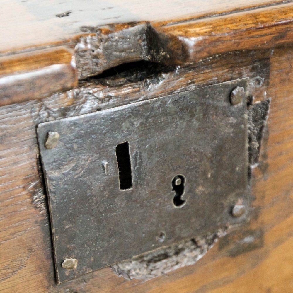 An 18th-century solid oak sword chest featuring a rectangular lift-top lid, iron lockplate, and cutout side supports. View XII