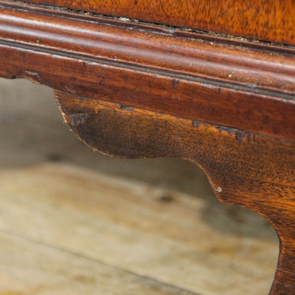 An antique mahogany writing bureau with a slant-front fall, four graduated drawers, oval brass handles, and bracket feet. View VII