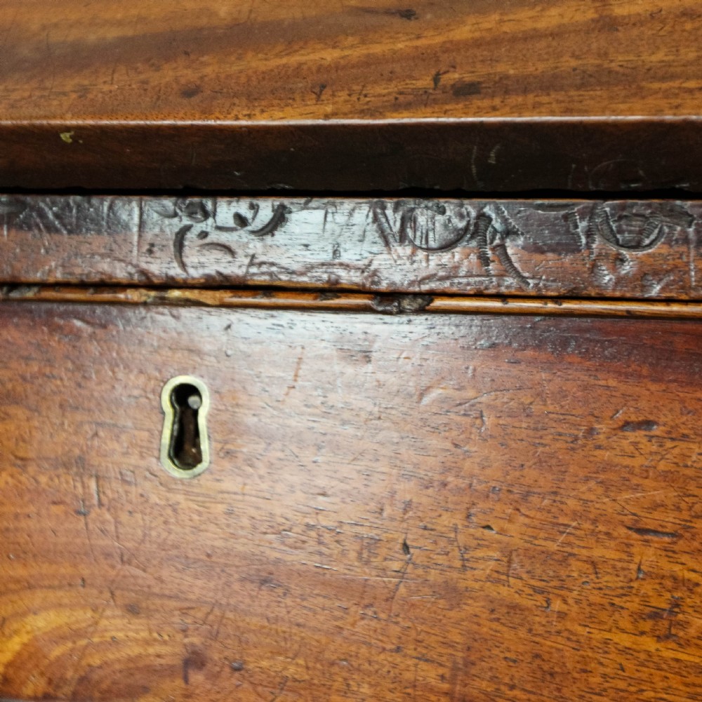 An antique mahogany writing bureau with a slant-front fall, four graduated drawers, oval brass handles, and bracket feet. View XI