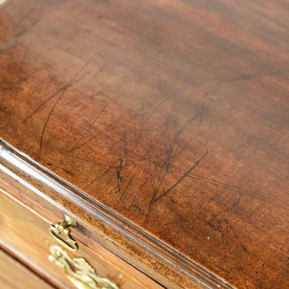 A Georgian mahogany bachelors chest of drawers featuring four graduated drawers with brass handles and a pull-out brushing slide set on bracket feet. View IX