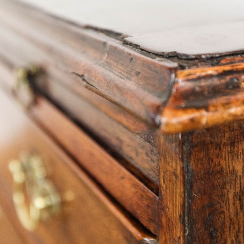 A Georgian mahogany bachelors chest of drawers featuring four graduated drawers with brass handles and a pull-out brushing slide set on bracket feet. View XII