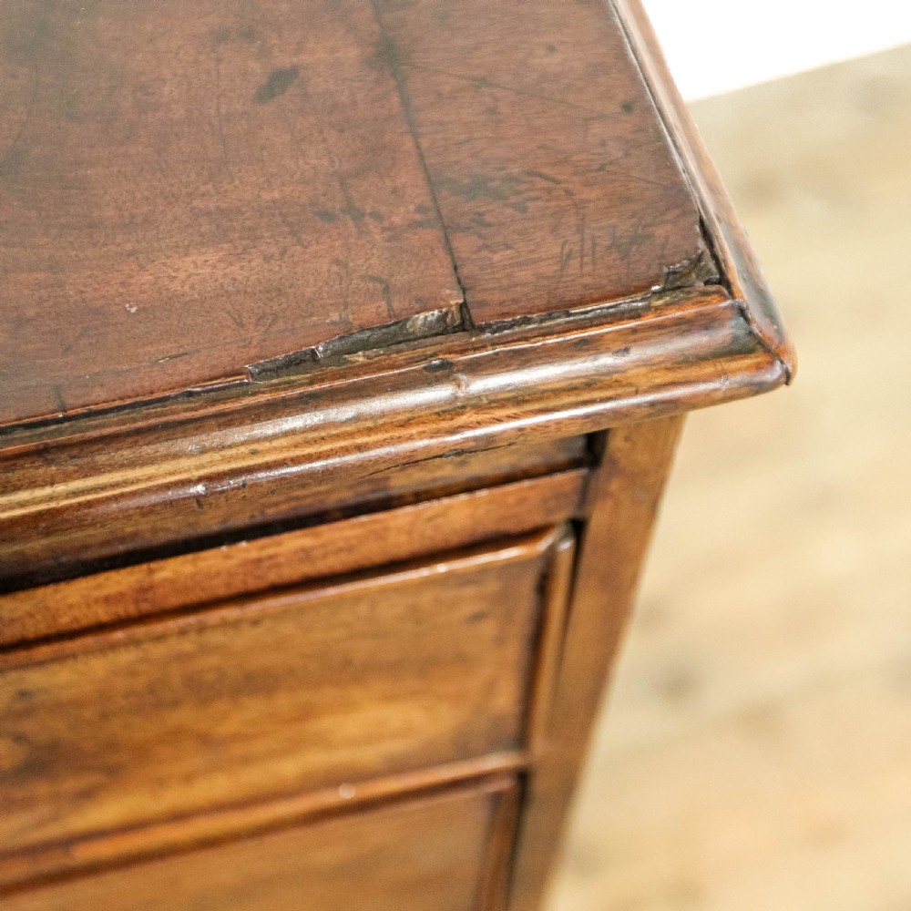 A Georgian mahogany bachelors chest of drawers featuring four graduated drawers with brass handles and a pull-out brushing slide set on bracket feet. View XIII
