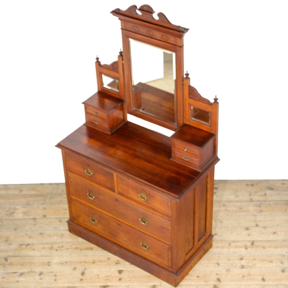 A Victorian carved oak dressing chest featuring an upper mirror superstructure with small side drawers and a lower three-tier chest of drawers on a plinth base. View III