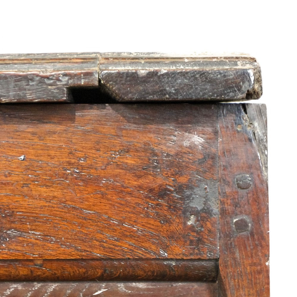 A 19th-century dark oak coffer featuring carved floral scroll panels, a decorative frieze, and sturdy block feet. View VI