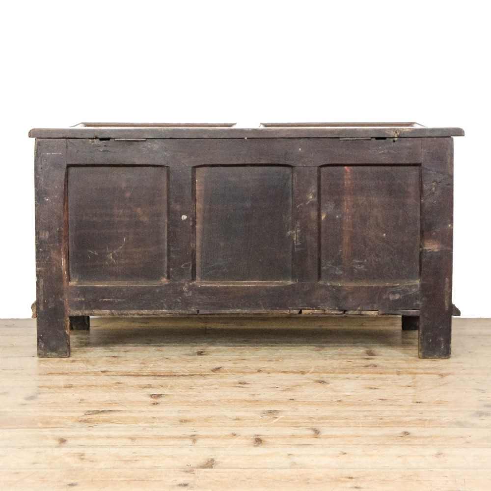 A 19th-century dark oak coffer featuring carved floral scroll panels, a decorative frieze, and sturdy block feet. View VII