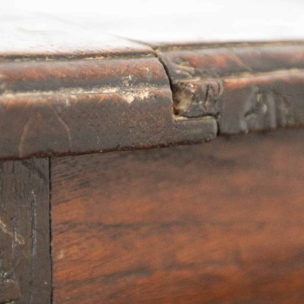 A 19th-century dark oak coffer featuring carved floral scroll panels, a decorative frieze, and sturdy block feet. View XI