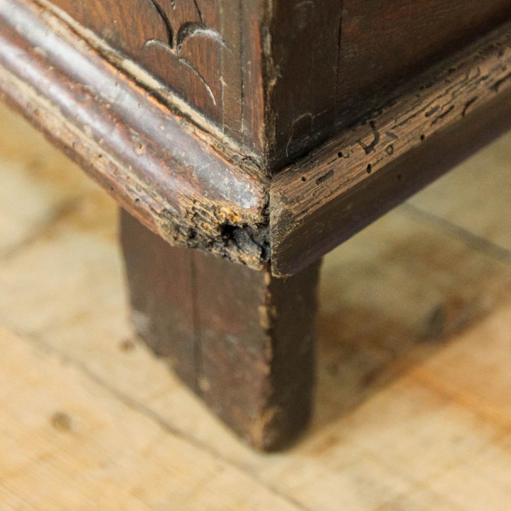 A 19th-century dark oak coffer featuring carved floral scroll panels, a decorative frieze, and sturdy block feet. View XII