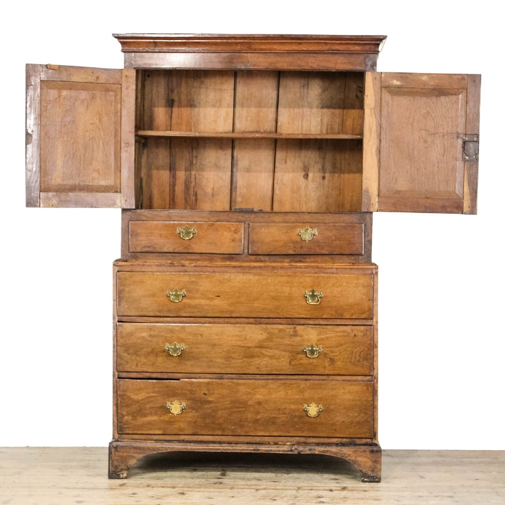 A nineteenth-century two-part oak housekeepers cupboard featuring twin panelled upper doors above two short and three long drawers with brass hardware. View III