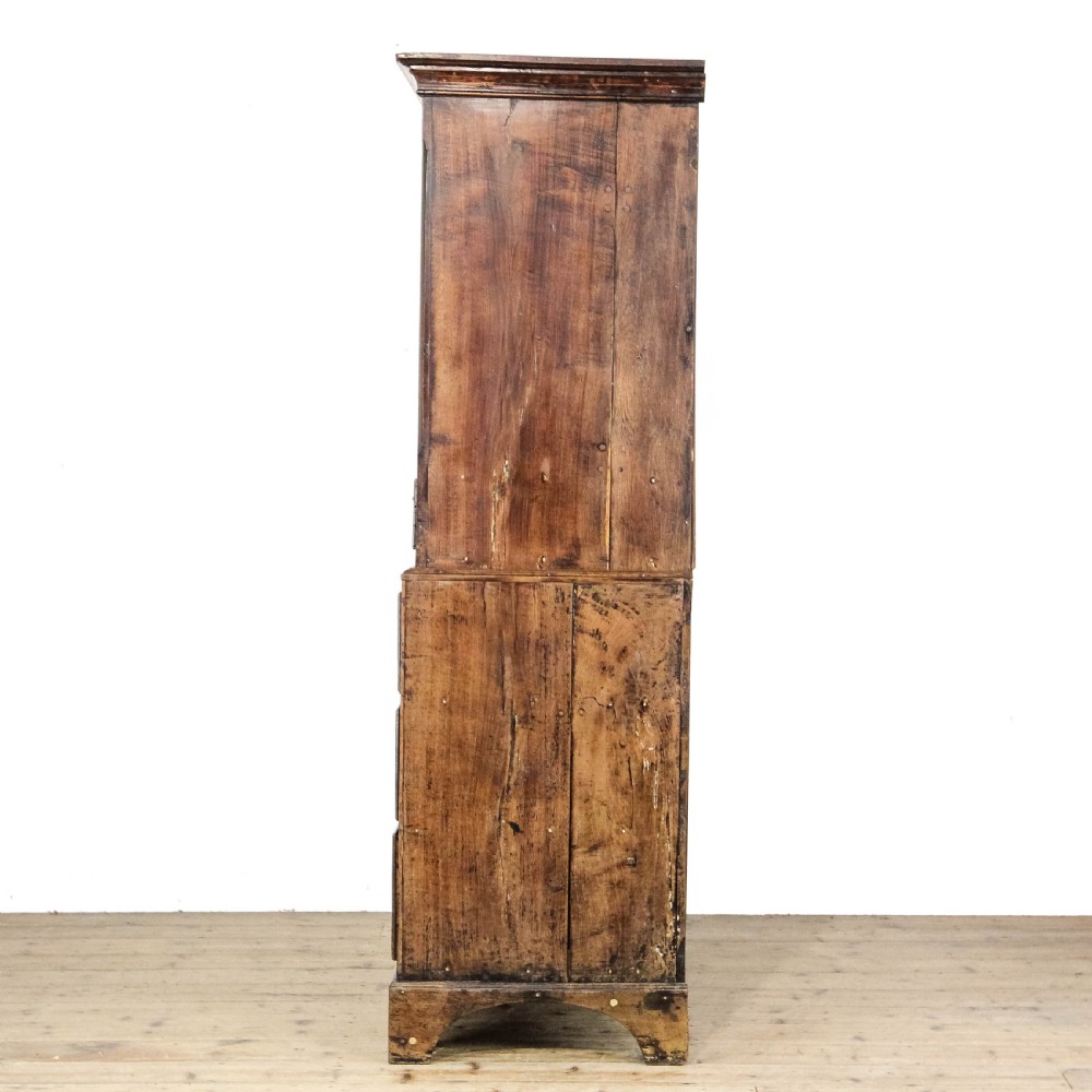 A nineteenth-century two-part oak housekeepers cupboard featuring twin panelled upper doors above two short and three long drawers with brass hardware. View V