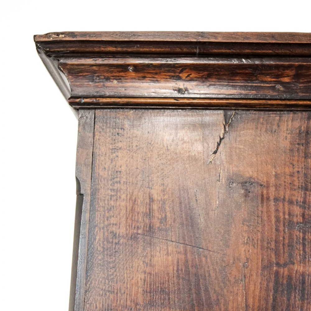 A nineteenth-century two-part oak housekeepers cupboard featuring twin panelled upper doors above two short and three long drawers with brass hardware. View VII