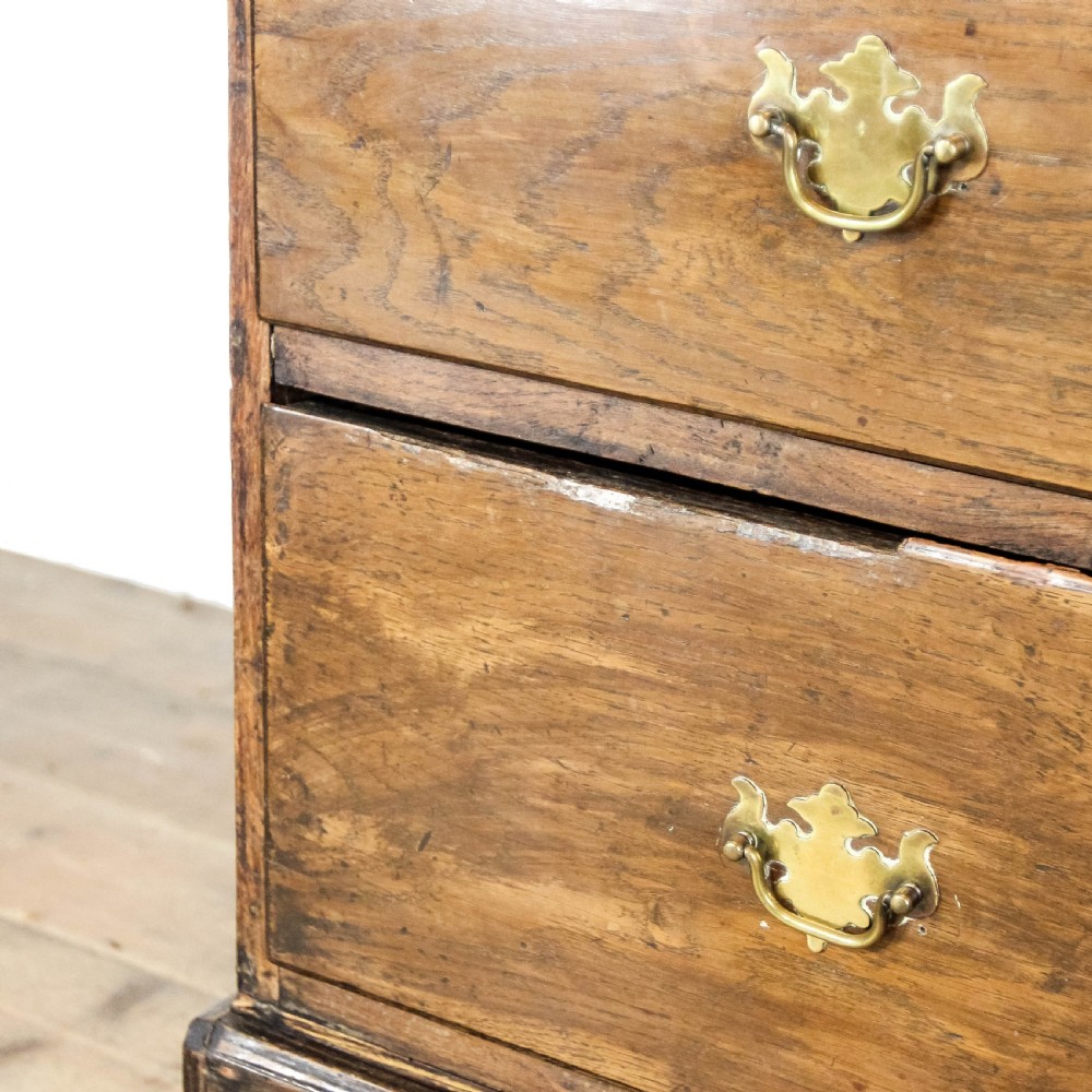 A nineteenth-century two-part oak housekeepers cupboard featuring twin panelled upper doors above two short and three long drawers with brass hardware. View XIII