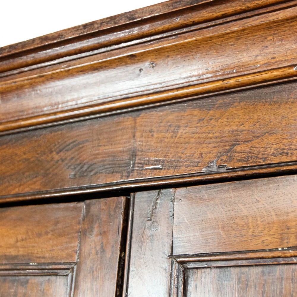 A nineteenth-century two-part oak housekeepers cupboard featuring twin panelled upper doors above two short and three long drawers with brass hardware. View XVII