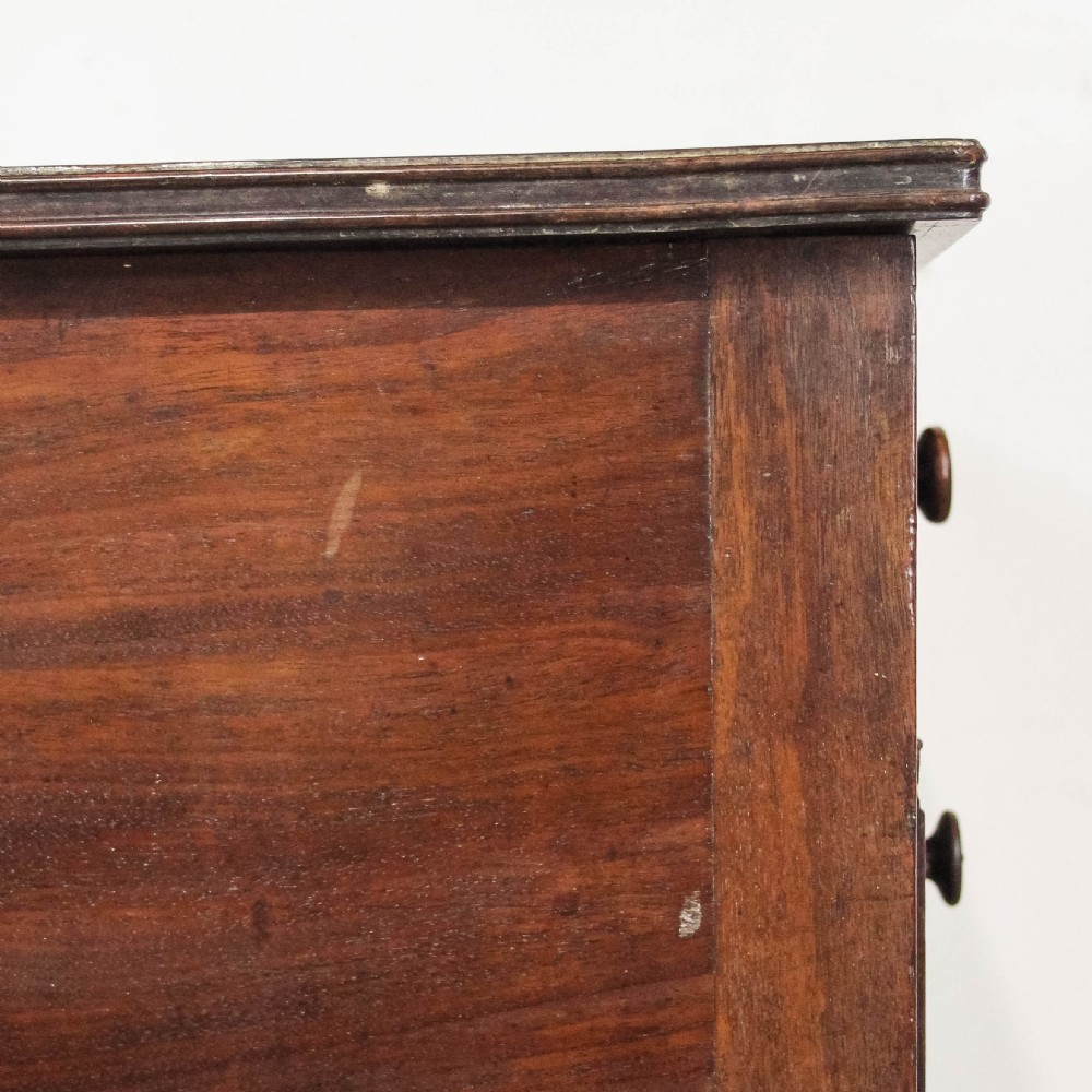 An antique dark mahogany writing desk featuring five drawers with turned wooden knobs and slender turned tapering legs. View VIII