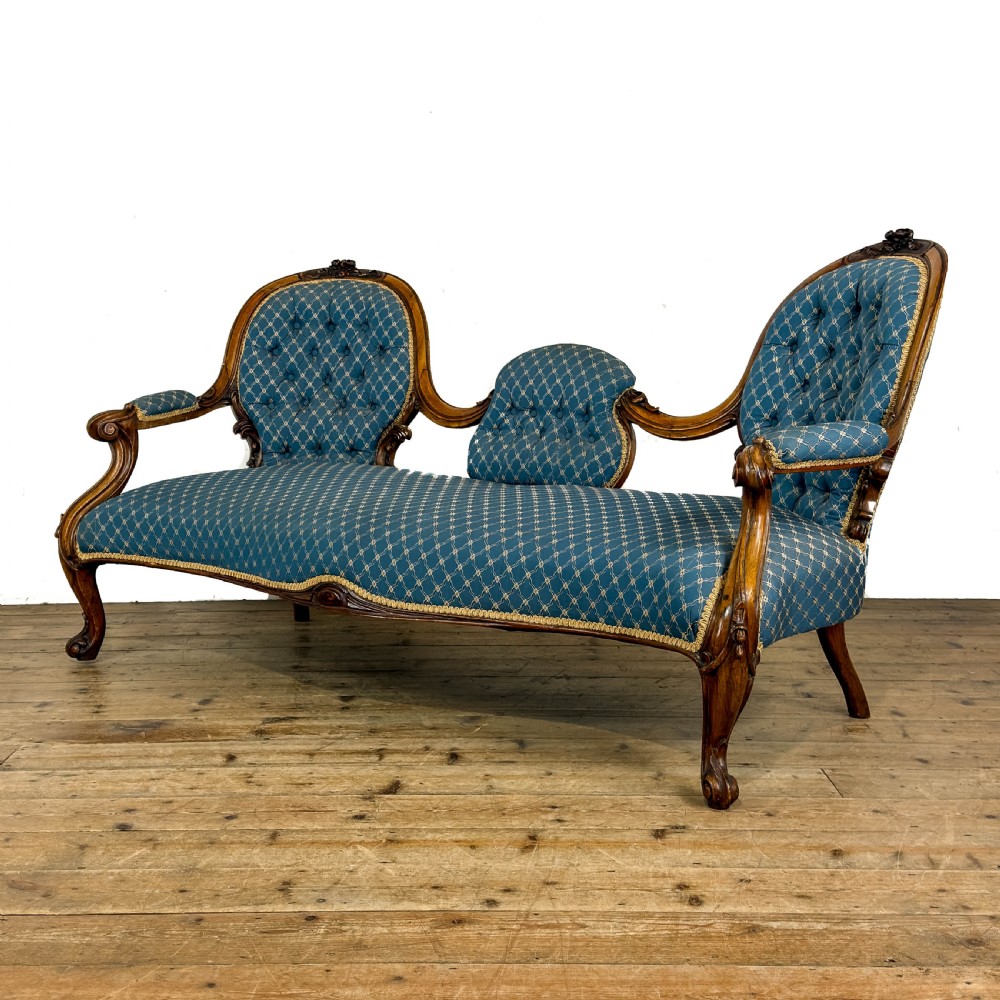 A Victorian carved walnut settee with double button-tufted balloon backrests and blue patterned fabric upholstery. View III