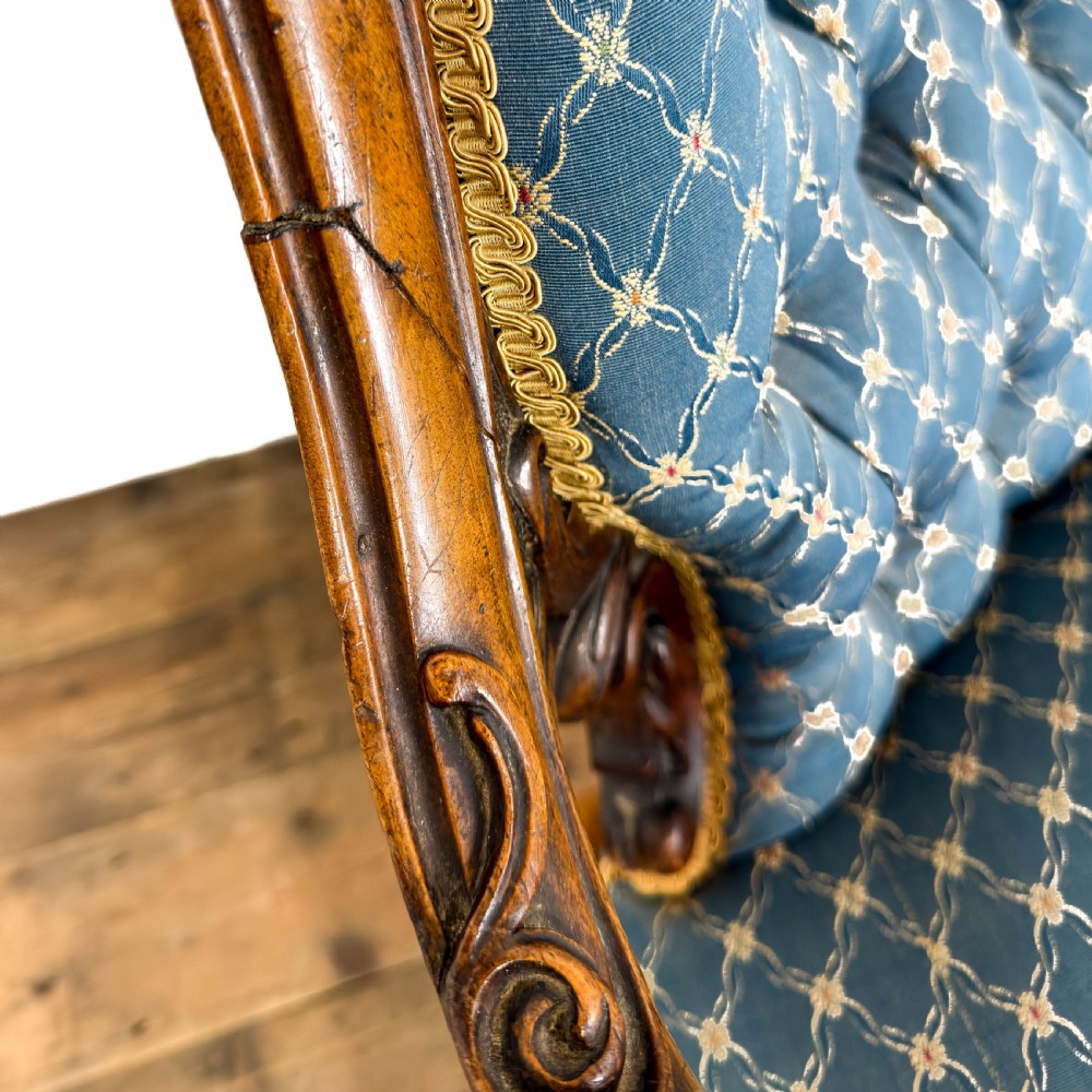 A Victorian carved walnut settee with double button-tufted balloon backrests and blue patterned fabric upholstery. View VII