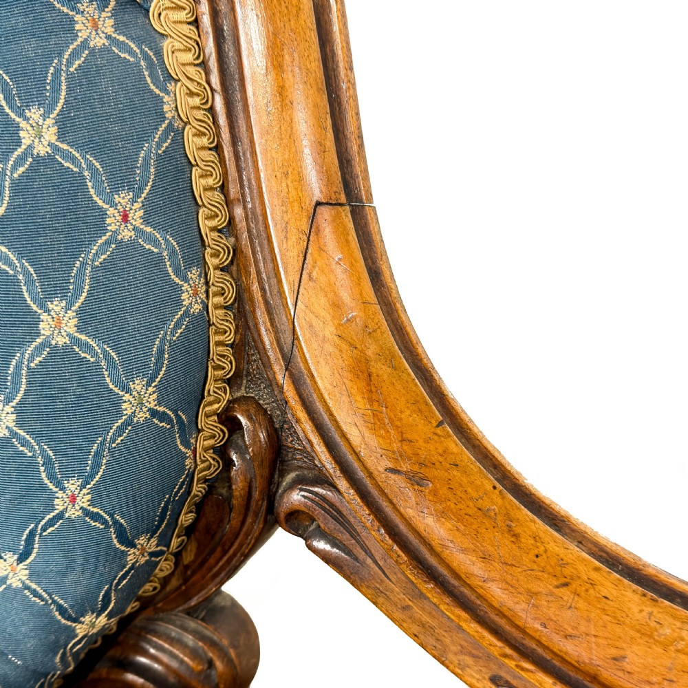 A Victorian carved walnut settee with double button-tufted balloon backrests and blue patterned fabric upholstery. View VIII