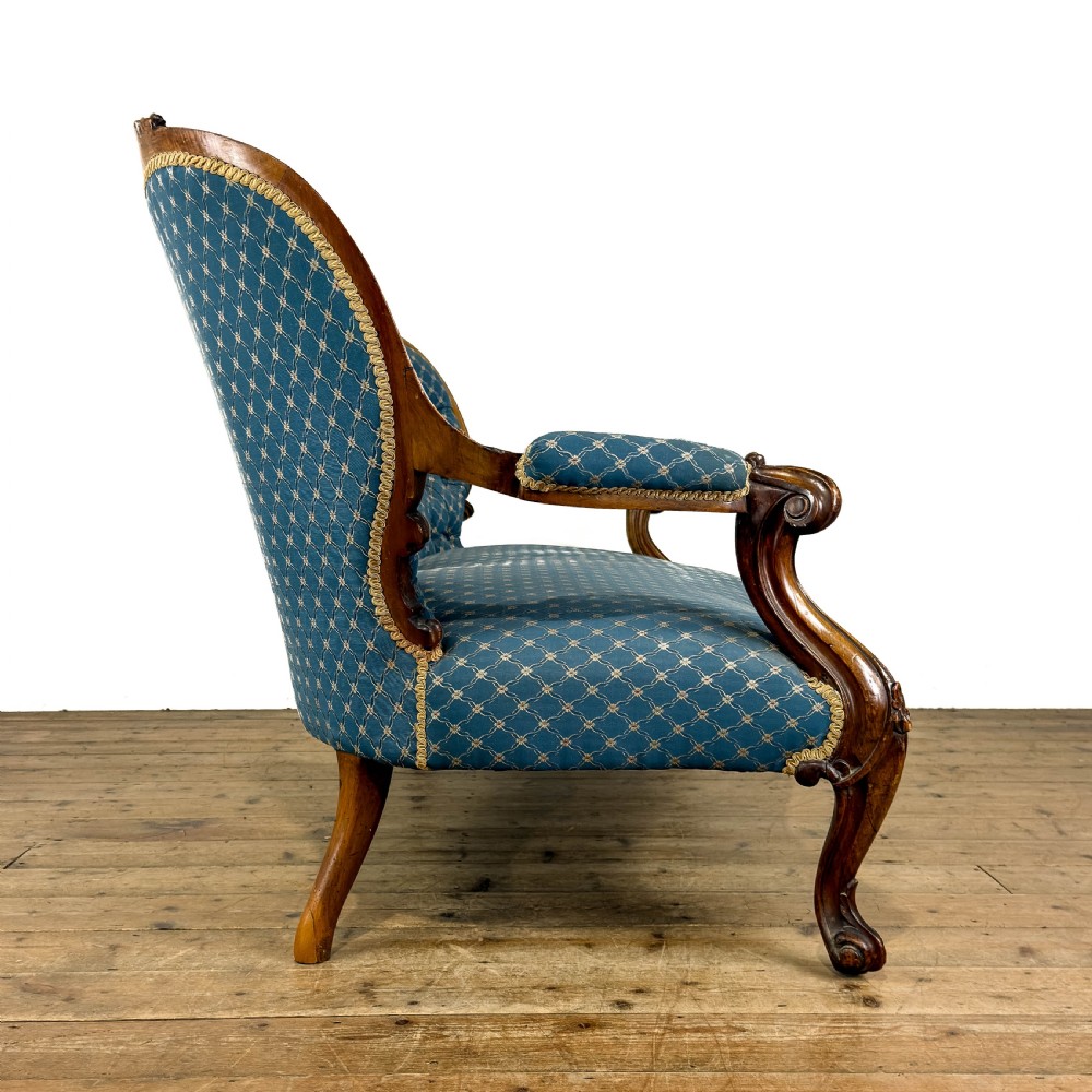 A Victorian carved walnut settee with double button-tufted balloon backrests and blue patterned fabric upholstery. View X