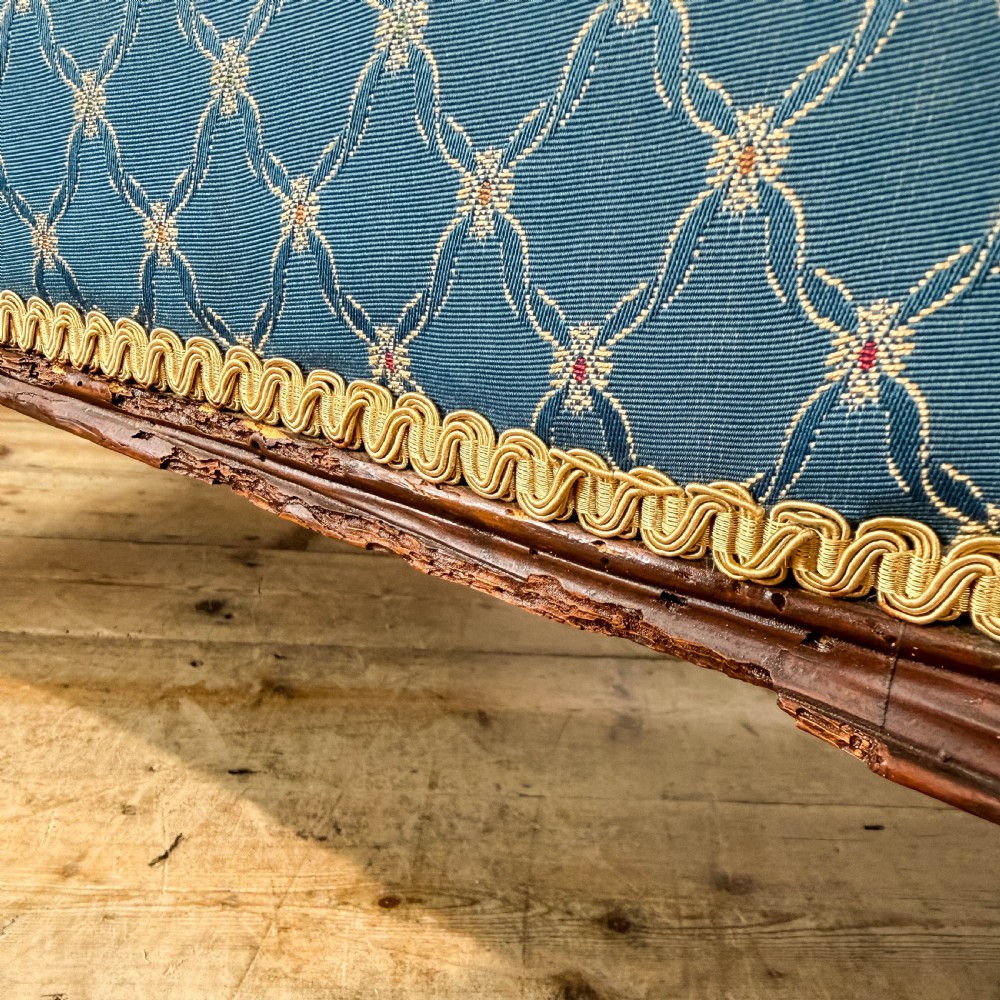 A Victorian carved walnut settee with double button-tufted balloon backrests and blue patterned fabric upholstery. View XI