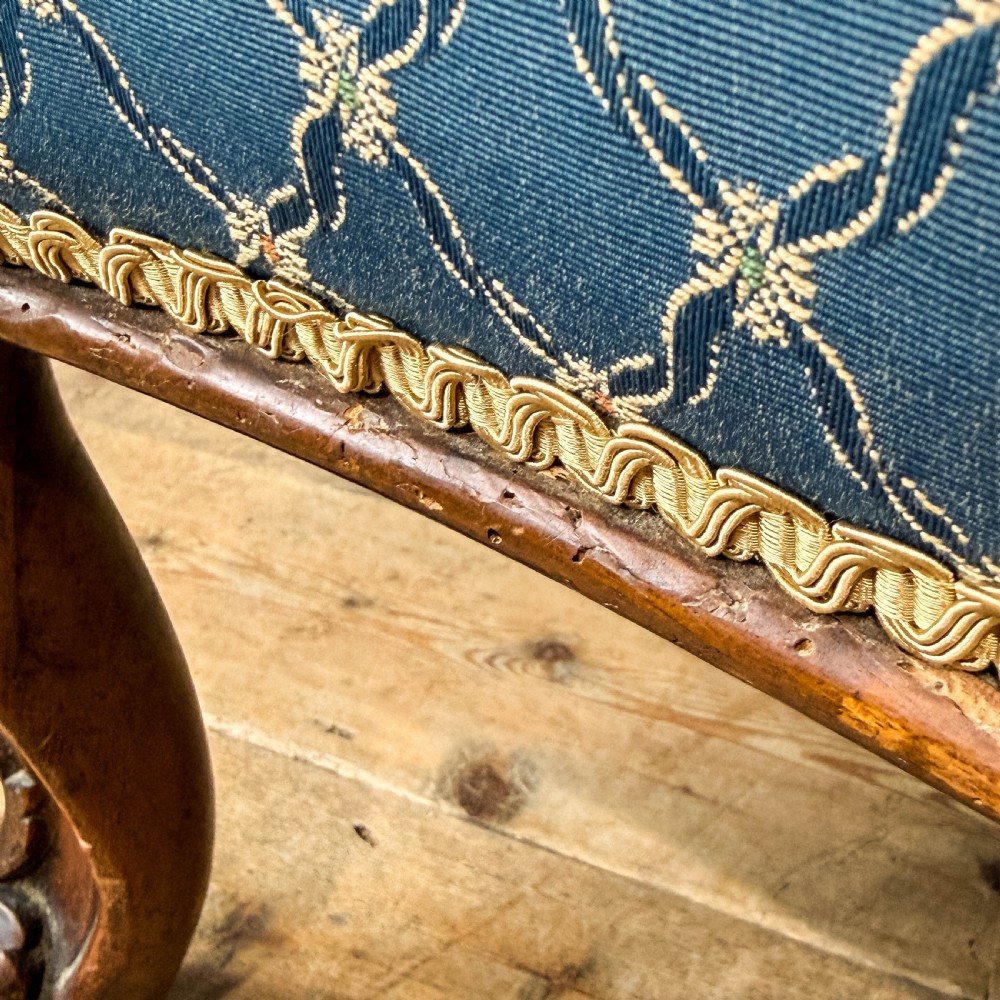 A Victorian carved walnut settee with double button-tufted balloon backrests and blue patterned fabric upholstery. View XII