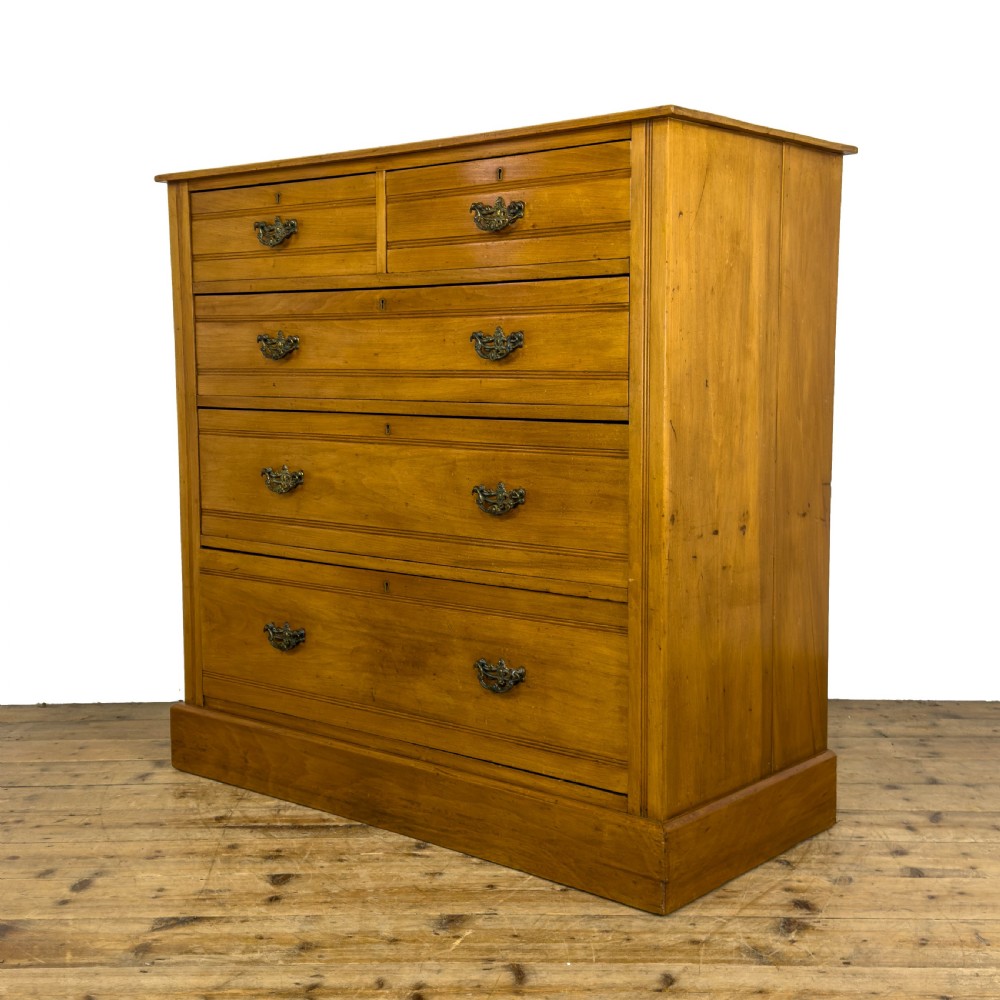 An Edwardian satinwood chest of drawers with two short drawers over three long drawers, featuring brass drop handles and a plinth base. View II