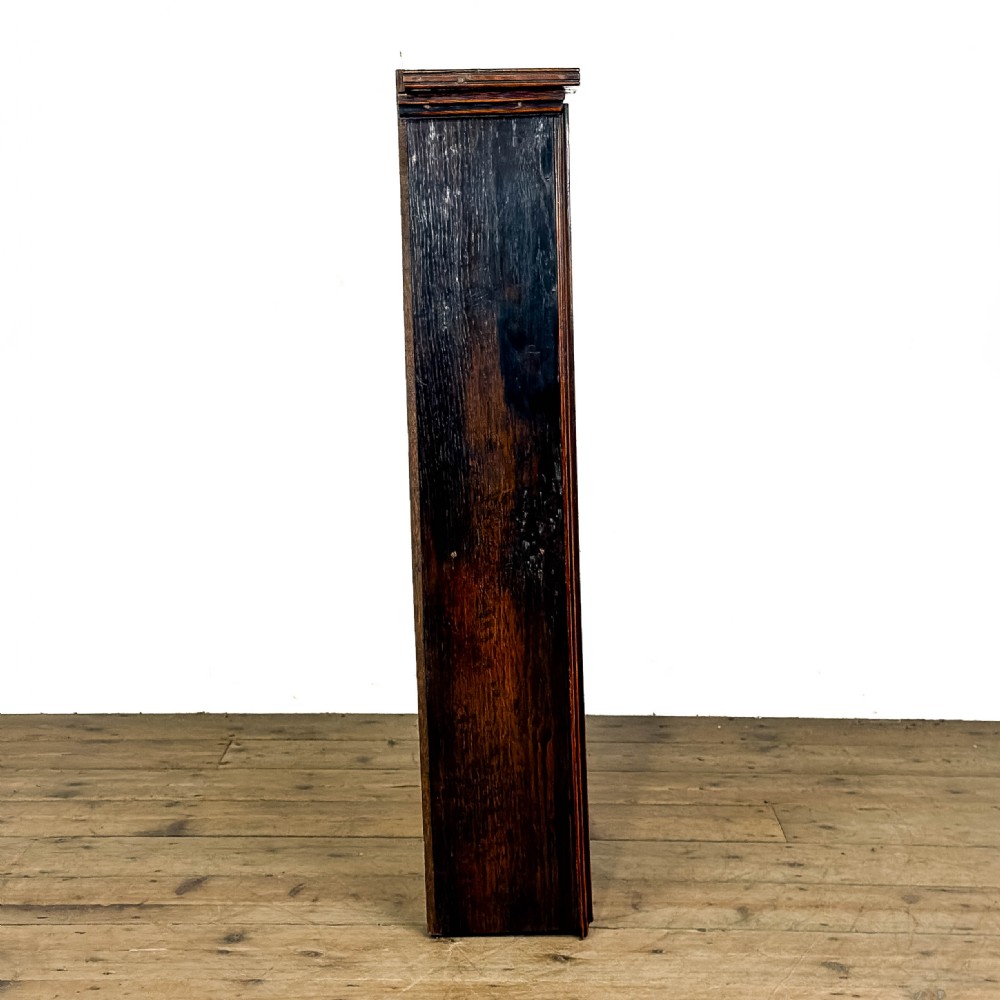 A dark brown oak two-tier wall-hanging shelf unit featuring a scalloped top frieze and vertical planked backboard. View VI