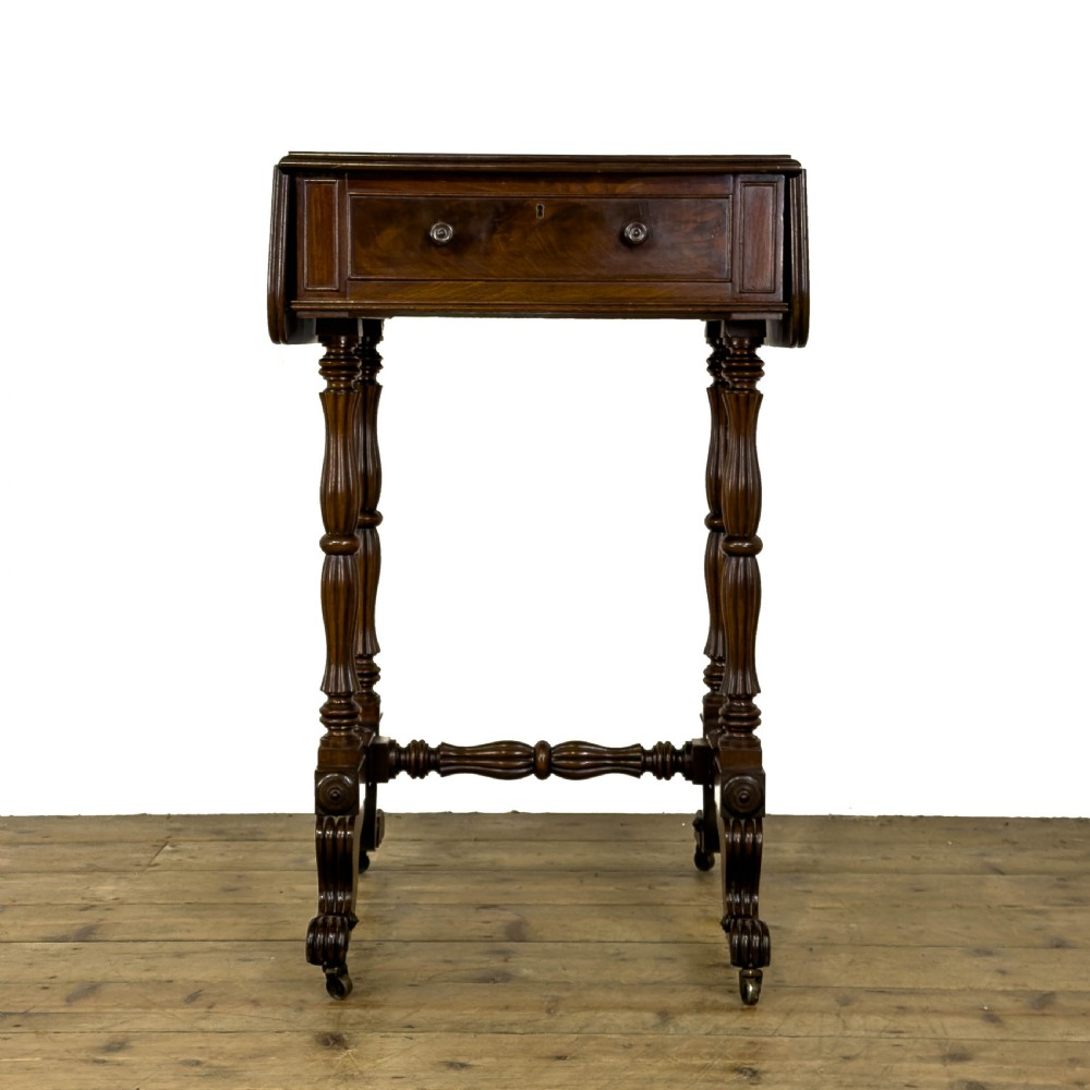 An antique Victorian dark mahogany drop-leaf work table featuring a single drawer with turned wooden knobs, fluted legs, and scroll feet on brass castors. View V